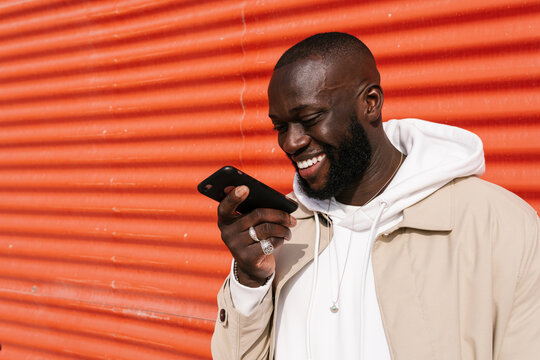 Afro man sending voice messages by mobile on the street