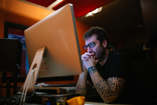 Sound engineer against computer in recording studio