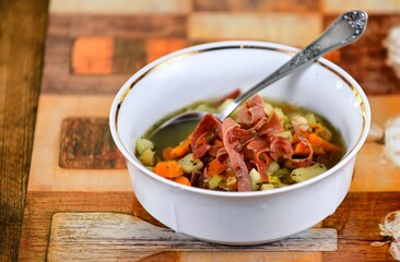 Vegetable soup on a plate on the wooden table