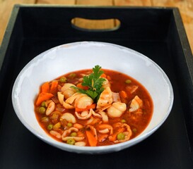 Vegetable soup on a plate on the wooden table