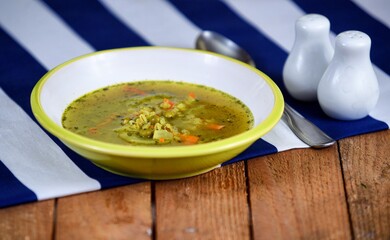 Vegetable soup on a plate on the wooden table