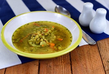 Vegetable soup on a plate on the wooden table