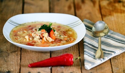 Vegetable soup on a plate on the wooden table