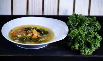 Vegetable soup on a plate on the wooden table