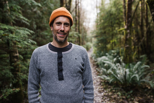 Man in toque or beanie in forest.