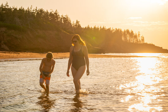 Mother and Son Walking and Exploring Red Sand Beach on PEI at Summer Vacation