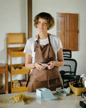 Portrait of a woman in a leather apron near work tabel 