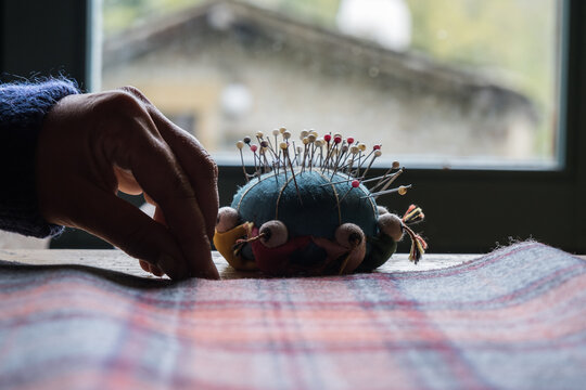 woman's hand using pins on fabric