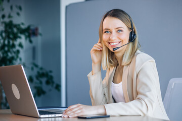 of a beautiful young business woman in headsets using laptops while working in the office.