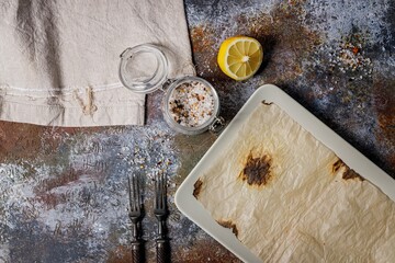 Empty rectangular plate. Rusty background. Forks, spices. Place for display. Top view. Copy space.