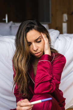 Sad woman with pregnancy test