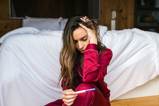 Sad woman with pregnancy test