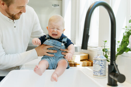 Father holding baby while he cries