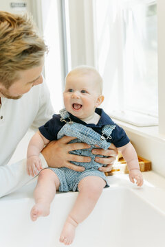 Father playing with newborn son
