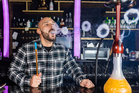 Man smoking hookah at night club