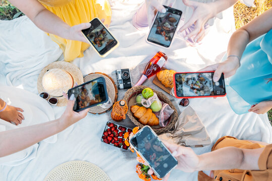 Social Media Content Ideas, Content creator for brands, food blog, summer picnic. Female hands, food blogger, content creator taking food photo via cell phone in picnic on nature background.