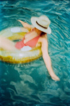 Woman floating on teal water