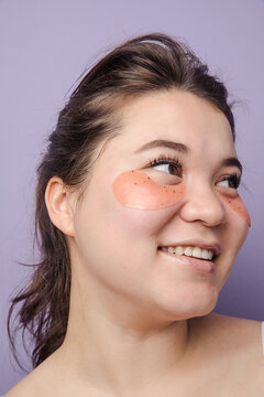 Young brunette east asian woman wearing  skincare under eye patch