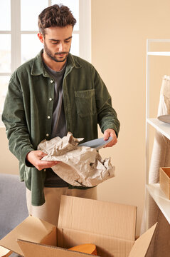 Male homeowner unwrapping plate over box