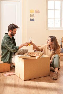 Optimistic young couple proposing toast in new flat