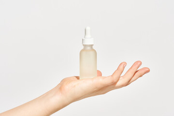 Woman showing bottle of cosmetic serum