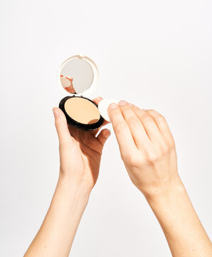 Woman with cosmetic powder and sponge