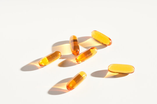 Yellow oil supplements capsules on table