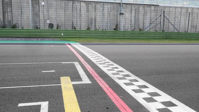 Concept of fast finish line milestone, racing car crossing asphalt checkered finish line with original engine sound