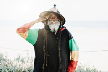 Serene hippie rastaman standing on field