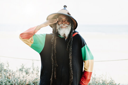 Serene hippie rastaman standing on field