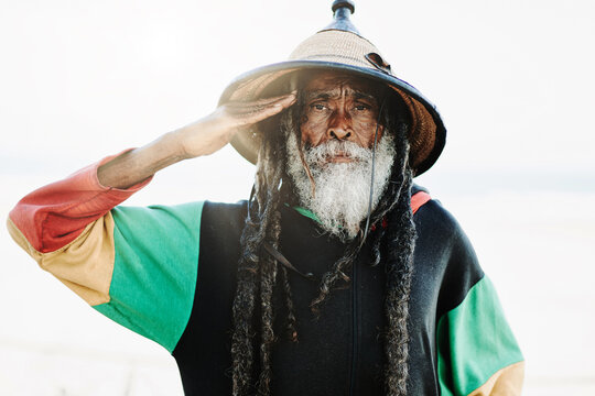 Serene hippie rastaman standing on field