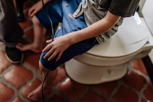 Young child holding wires from clipper as he gets his hair cut