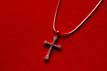 Crystal cross shaped pendant on gold chain isolated over white