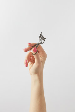 Woman holding eyelash curler