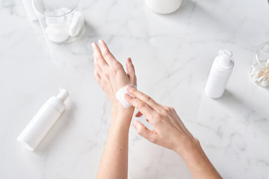 Woman applying foam on hand.
