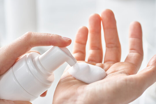 Hands applying foamy soap.