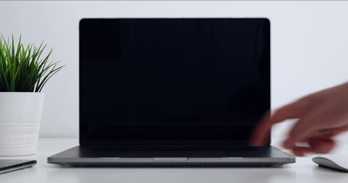 Man is opening the laptop with his hand and turning on the display - blank screen template