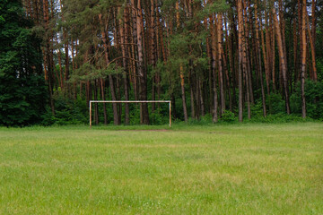 Football field in the morning woods. Football gates on a pine background. Ukraine. © Ganna Zelinska