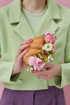 Woman holding croissant with flowers