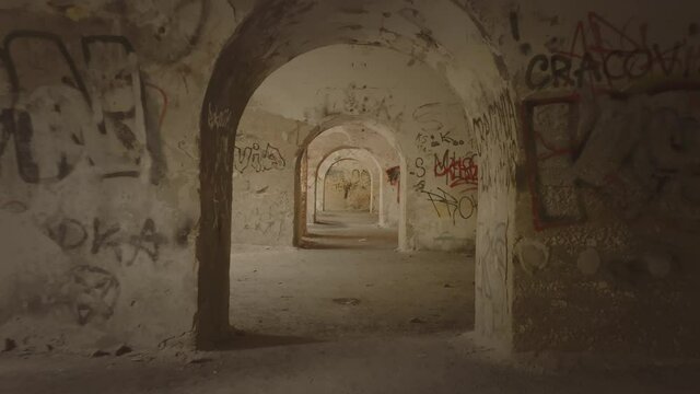 High speed forward dolly, zoom in through dark corridor with graffiti walls.