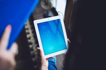Faceless woman using tablet while working at cafe