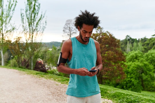 Fit Man Checking His Phone During A Run