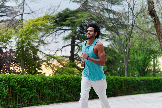 Fit young man running on a park path