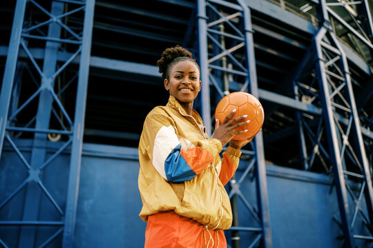Female footballer with ball in city