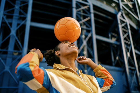 Female footballer with ball in city