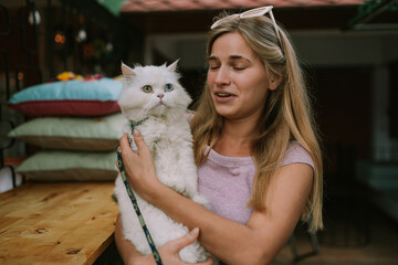 Smiling woman holding cat outdoors