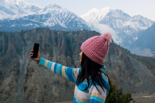 A young woman taking a selfie in the Himalayas