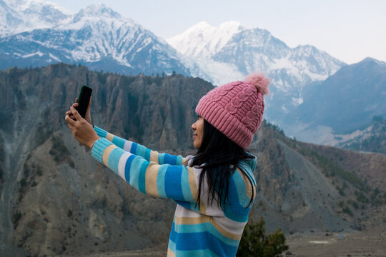 A young woman taking a selfie in the Himalayas