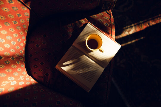 cup of coffee with book on an armchair
