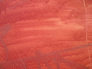 The yellow wall is painted on top with a dark red sloppy. The texture is streaked with stains. Copy space. 